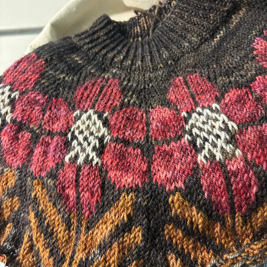 Knit fabric with floral pattern held by a hand