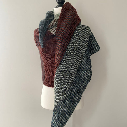 a brioche and garter shawl hanging on a mannequin against a white background